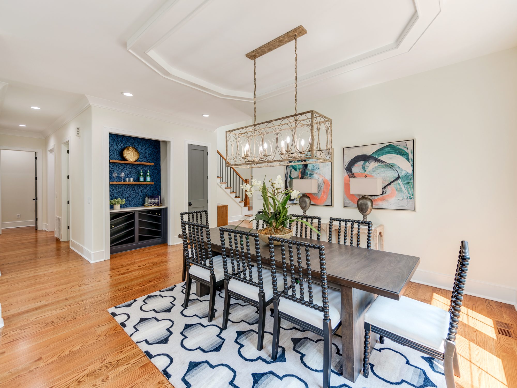 Dining table beneath brass chandelier with views to the backyard — Brantham by Stillman Properties Charlotte NC
