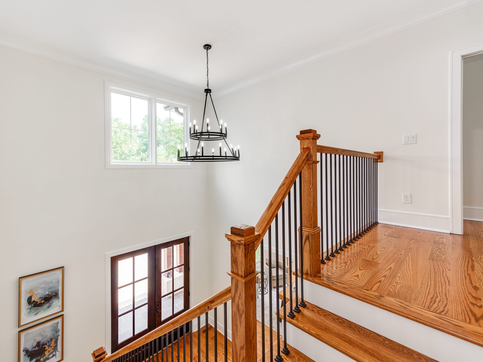 Upstairs landing with wagon-wheel chandelier overlooking the foyer — Brantham by Stillman Properties Charlotte NC
