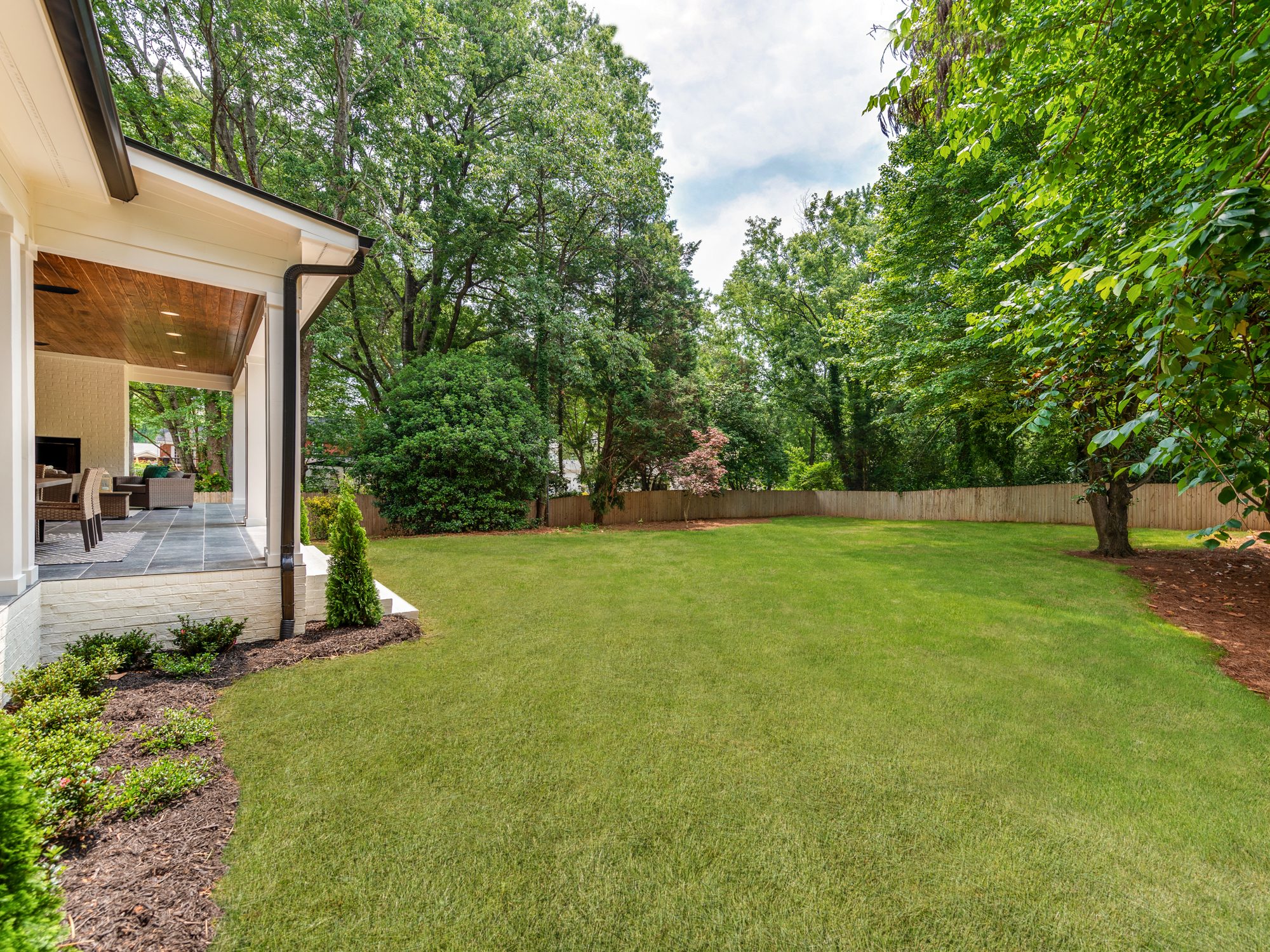 Flat, fully fenced backyard with mature tree line — Brantham by Stillman Properties Charlotte NC