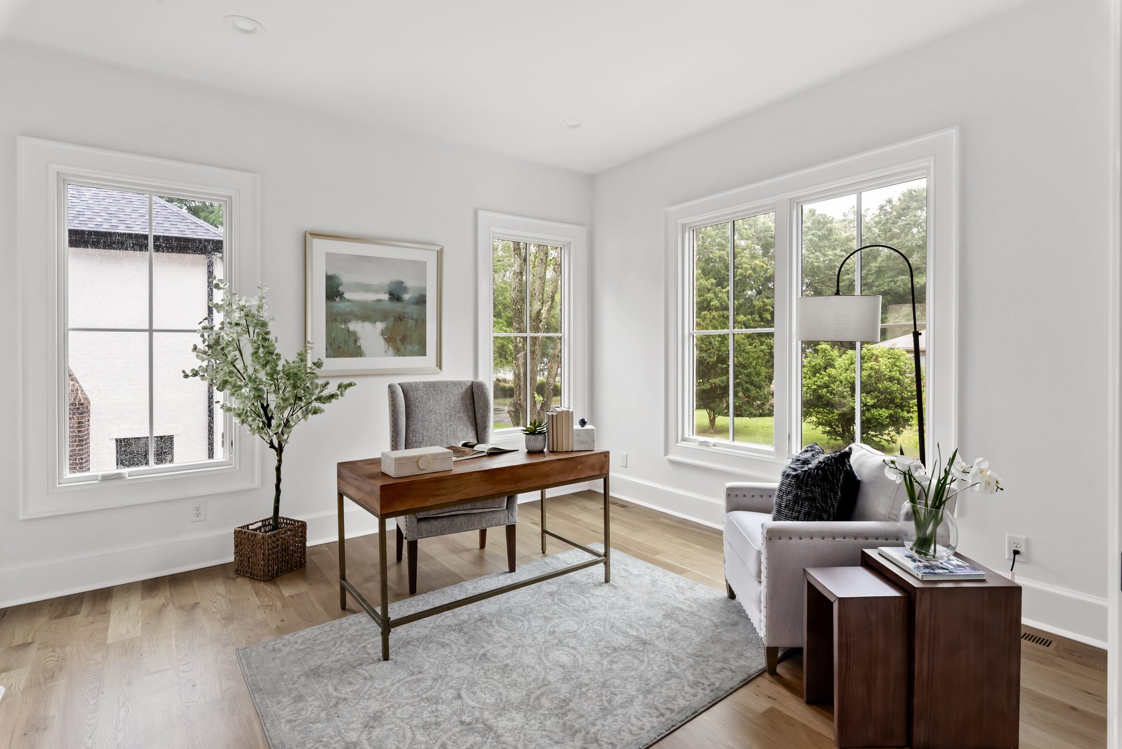 Front home office with three-window exposure, writing desk, and reading chair — Bywood by Stillman Properties Charlotte NC