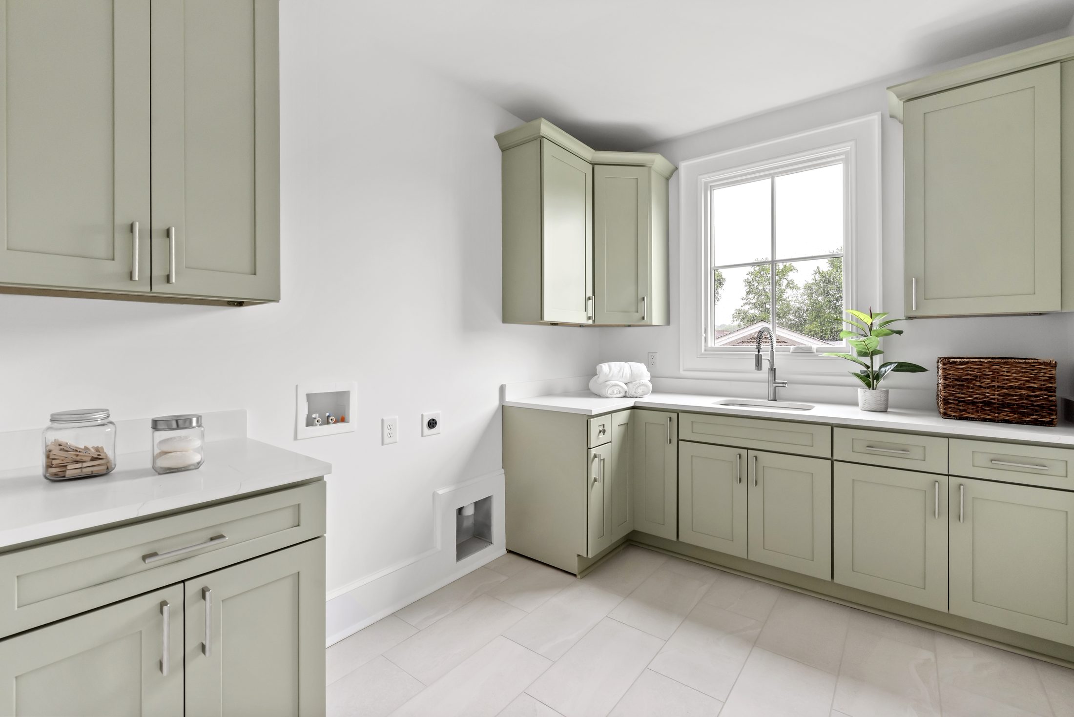 Spacious laundry room with sage-green cabinetry, quartz counters, and utility sink — Bywood by Stillman Properties Charlotte NC