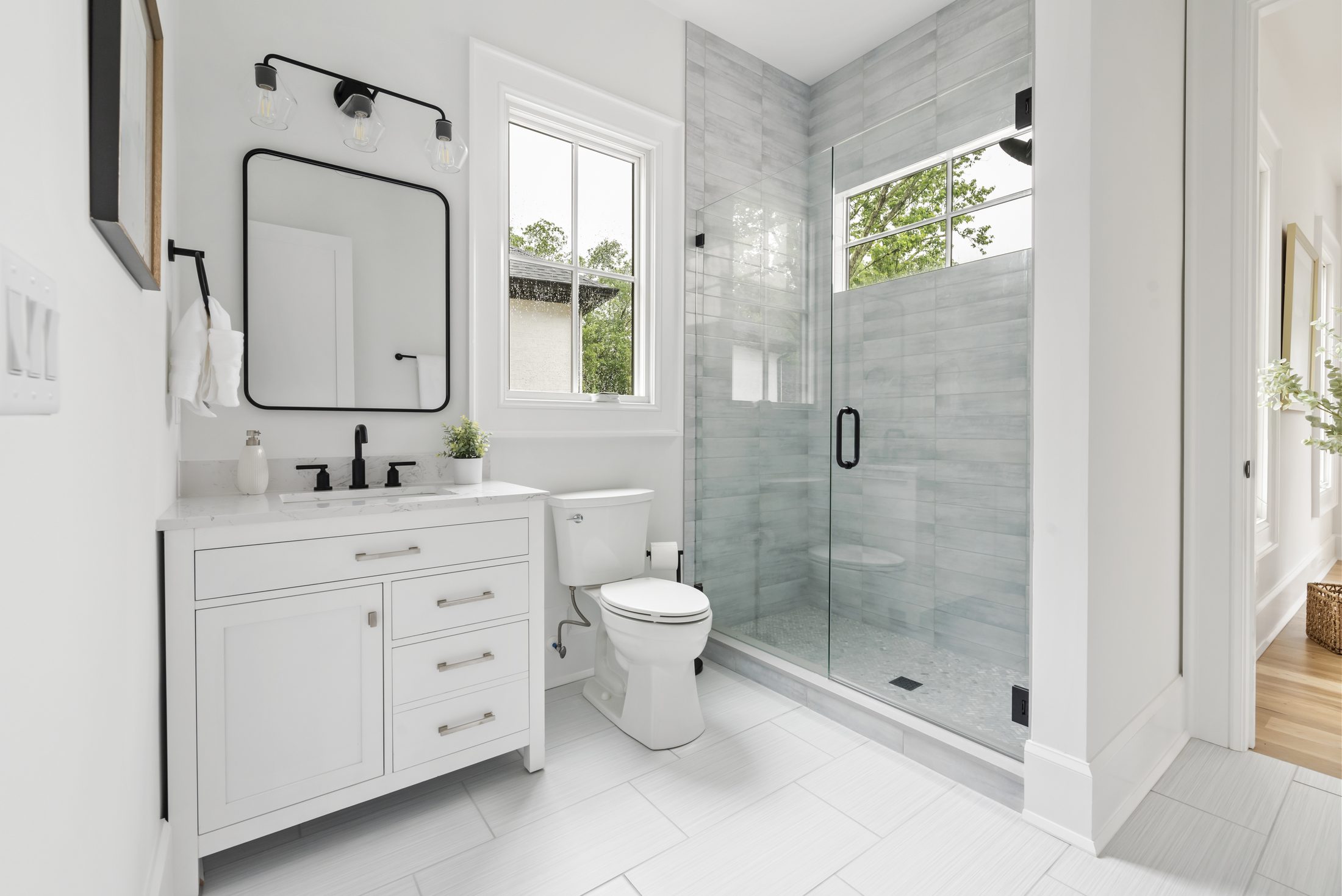 Secondary bath with white vanity, framed mirror, and glass-enclosed tile shower — Bywood by Stillman Properties Charlotte NC