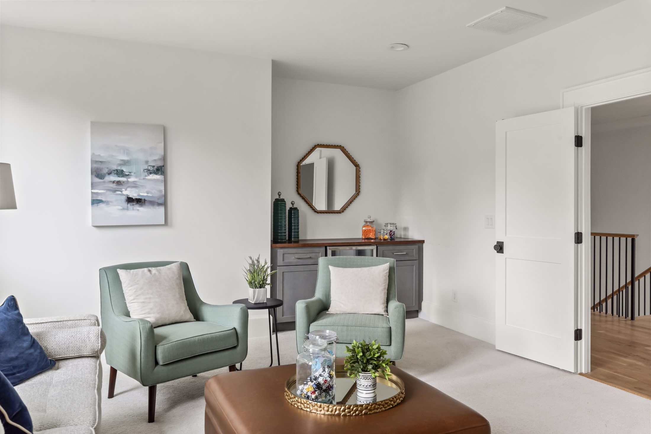 Upstairs loft sitting area with green accent chairs and a wet bar — Bywood by Stillman Properties Charlotte NC