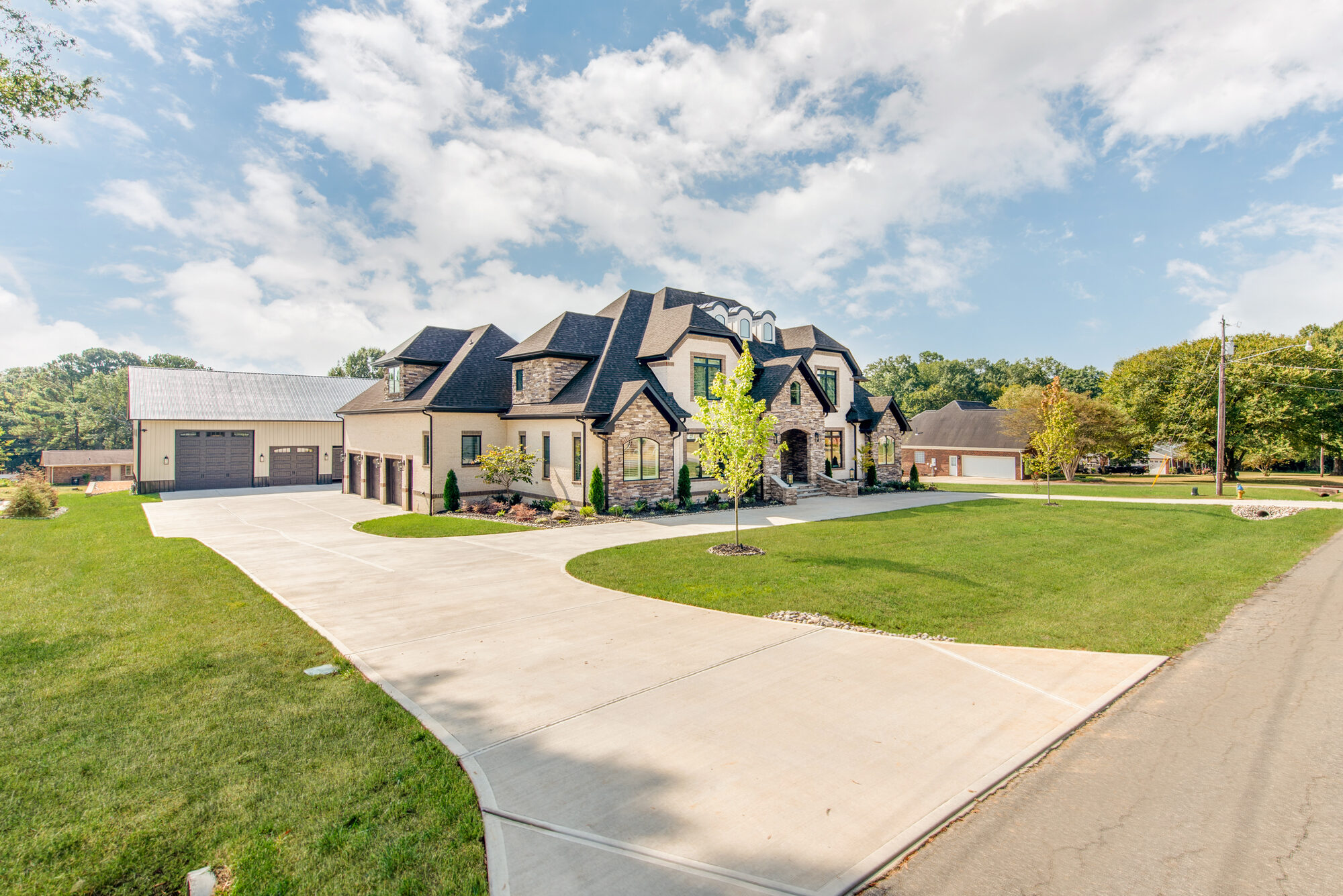 Wide property view of Coddle Creek showing the main residence and barndominium garage beyond — Stillman Properties Concord NC