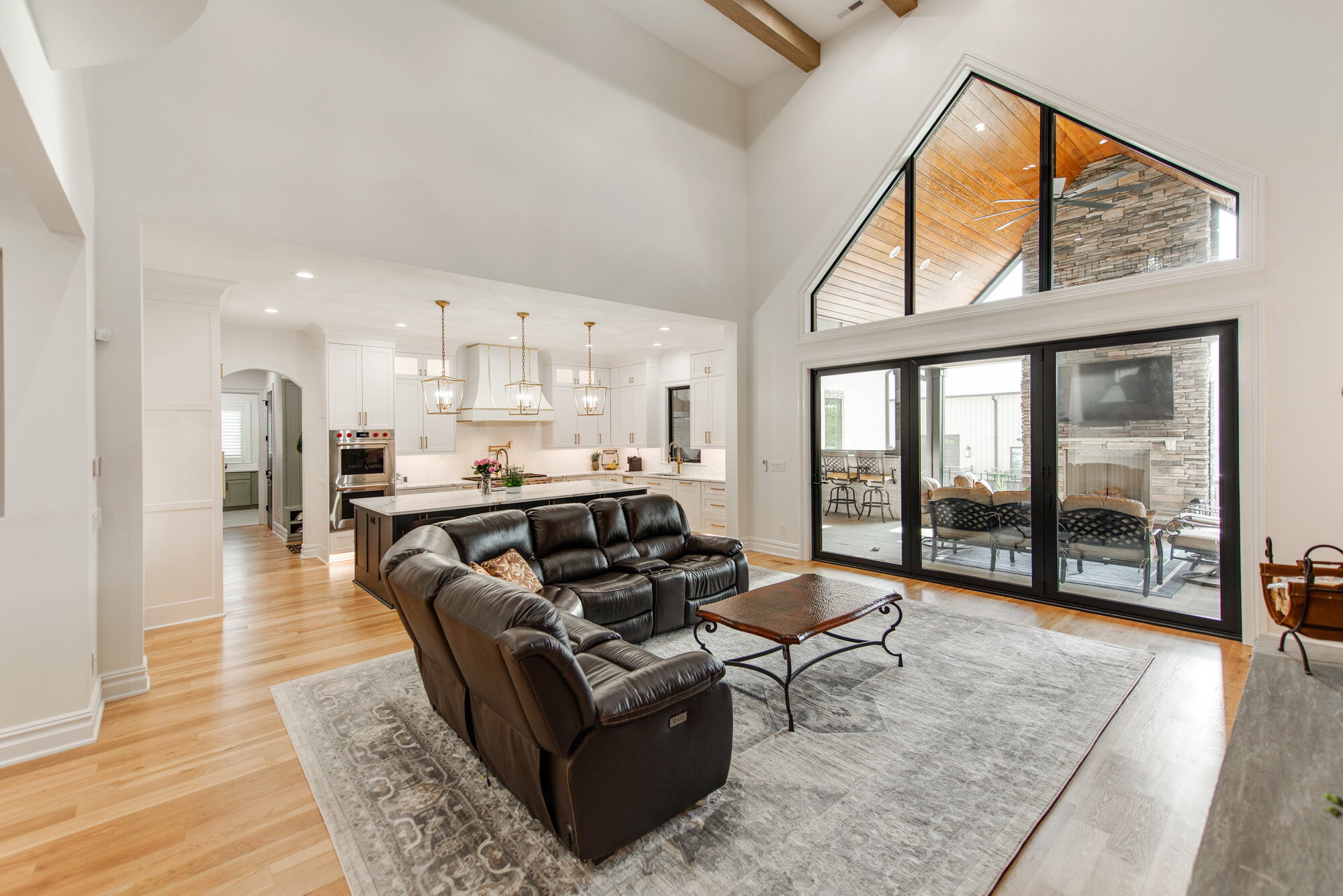 Great room cathedral window wall opening to the covered patio with outdoor fireplace — Coddle Creek by Stillman Properties Concord NC