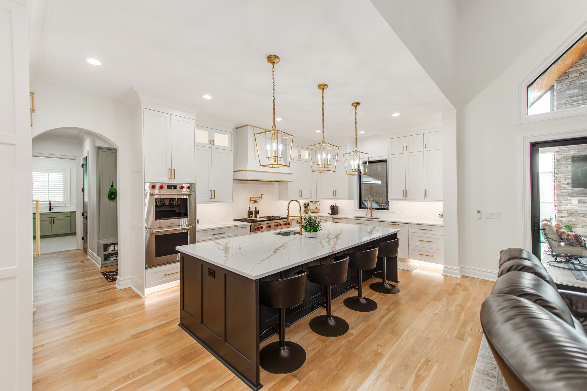 Chef's kitchen with oversized calacatta island, brass lantern pendants, and custom range hood — Coddle Creek by Stillman Properties Concord NC