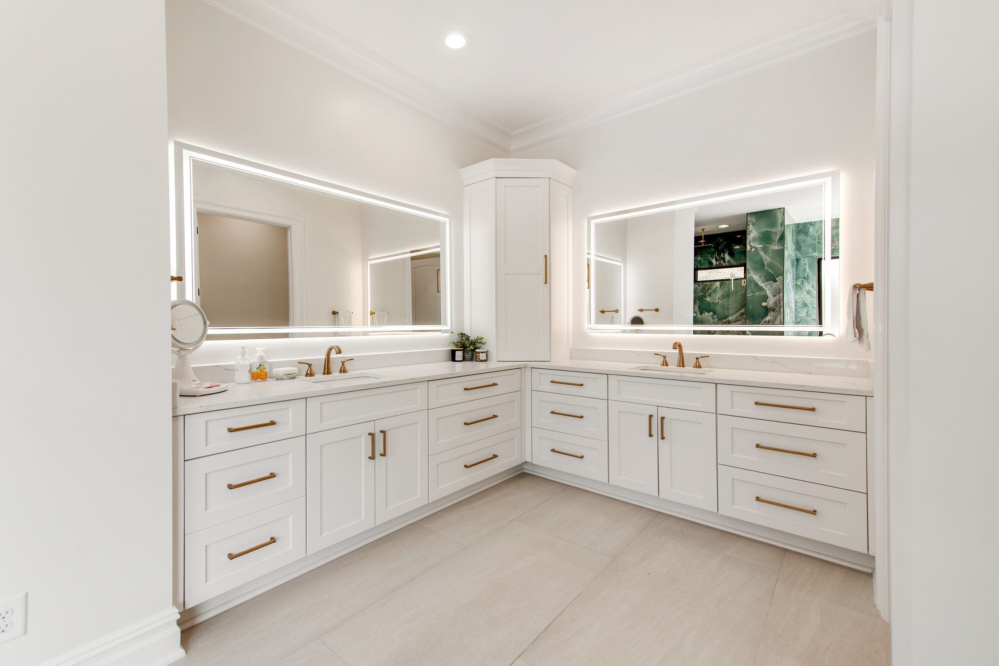 Primary spa bath with paired LED-edge vanities, brass fixtures, and corner linen tower — Coddle Creek by Stillman Properties Concord NC