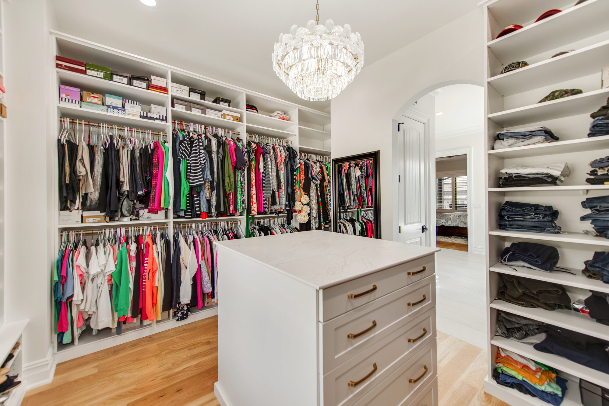 Primary closet her side with full-height hanging, shoe boxes, and folded display shelving — Coddle Creek by Stillman Properties Concord NC