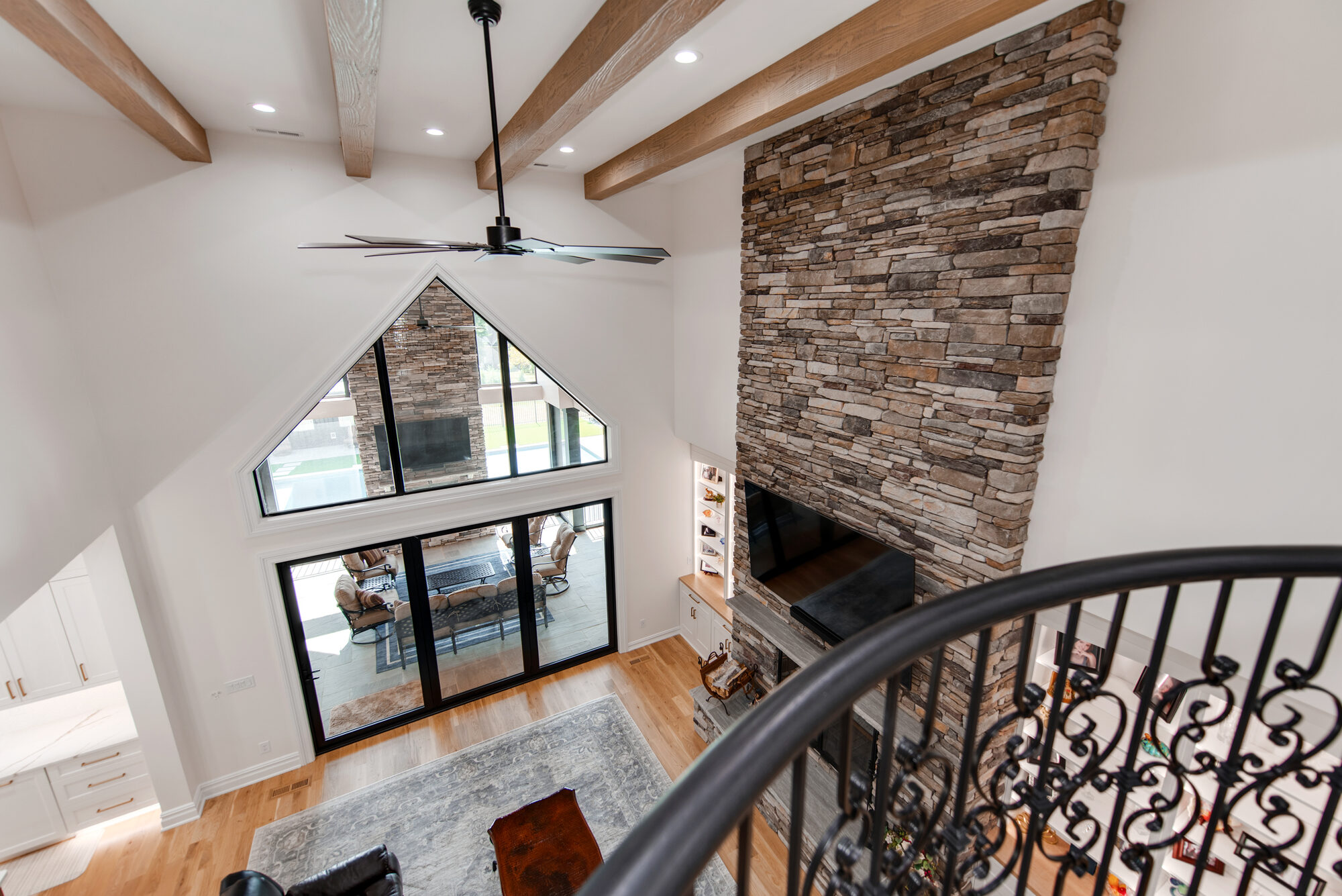 Upstairs overlook view down to the great room cathedral window and outdoor patio beyond — Coddle Creek by Stillman Properties Concord NC