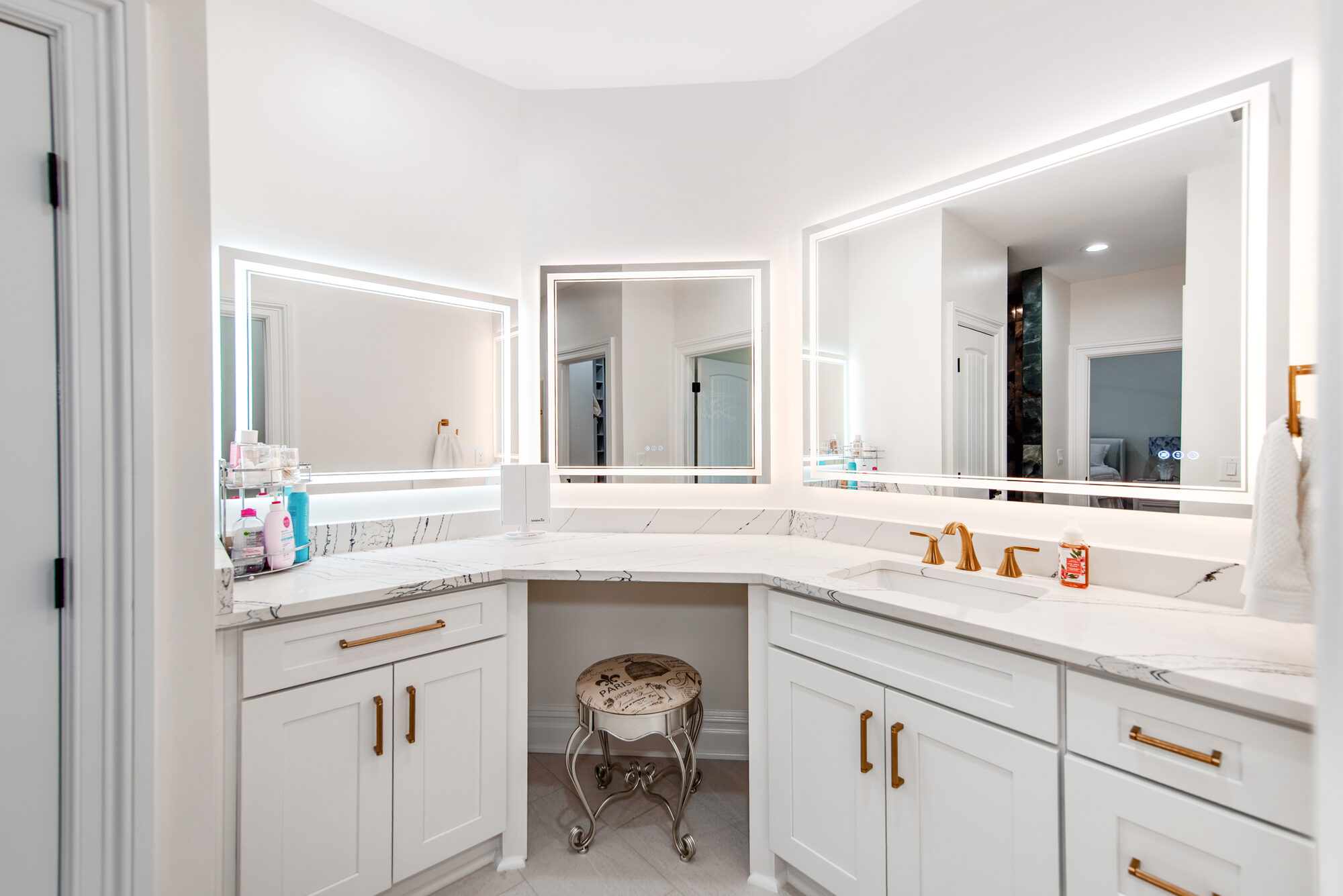 Guest bath corner vanity with three LED mirrors and brass fixtures — Coddle Creek by Stillman Properties Concord NC
