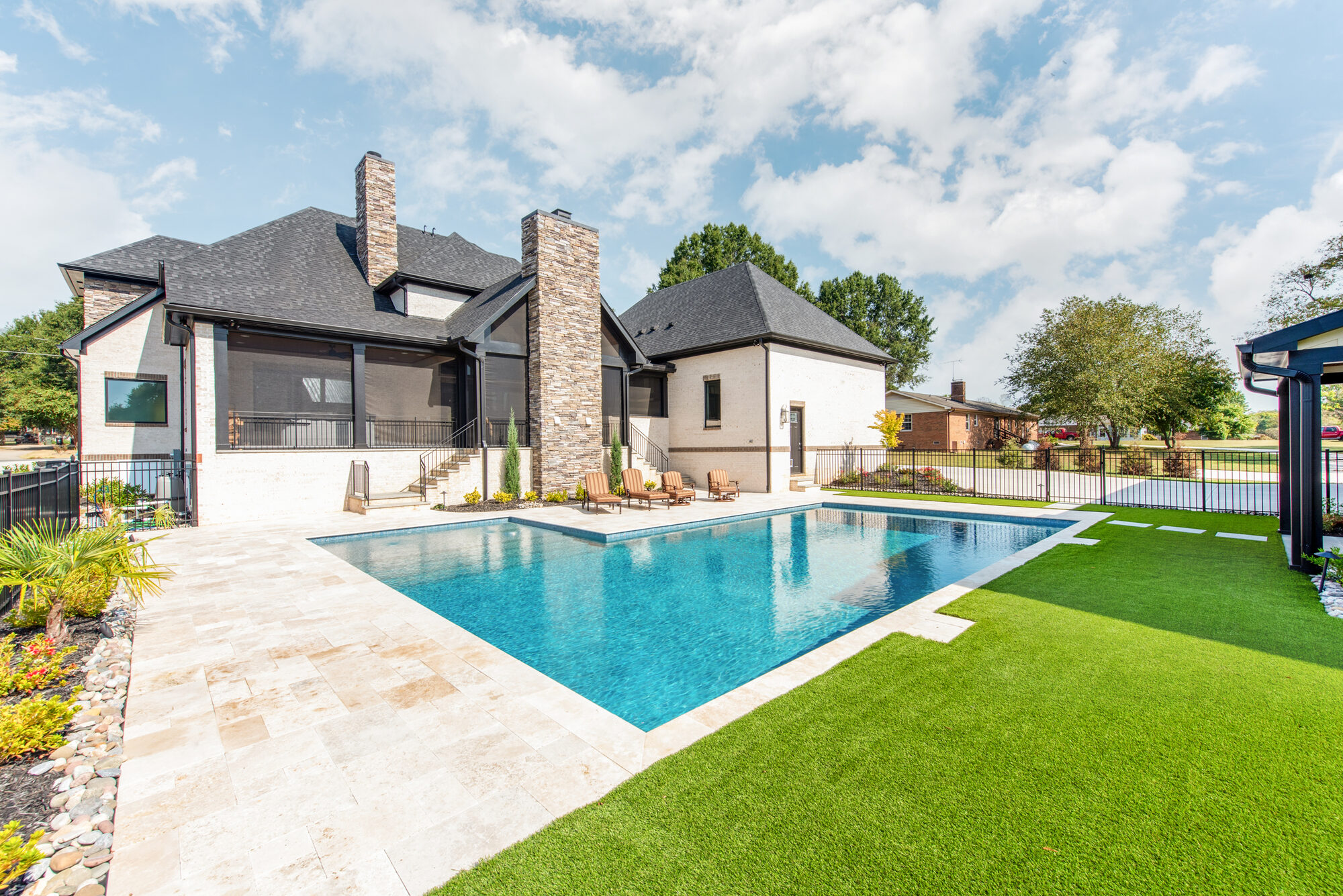 Wide rear view of Coddle Creek with travertine pool deck and stacked stone chimney — Stillman Properties Concord NC