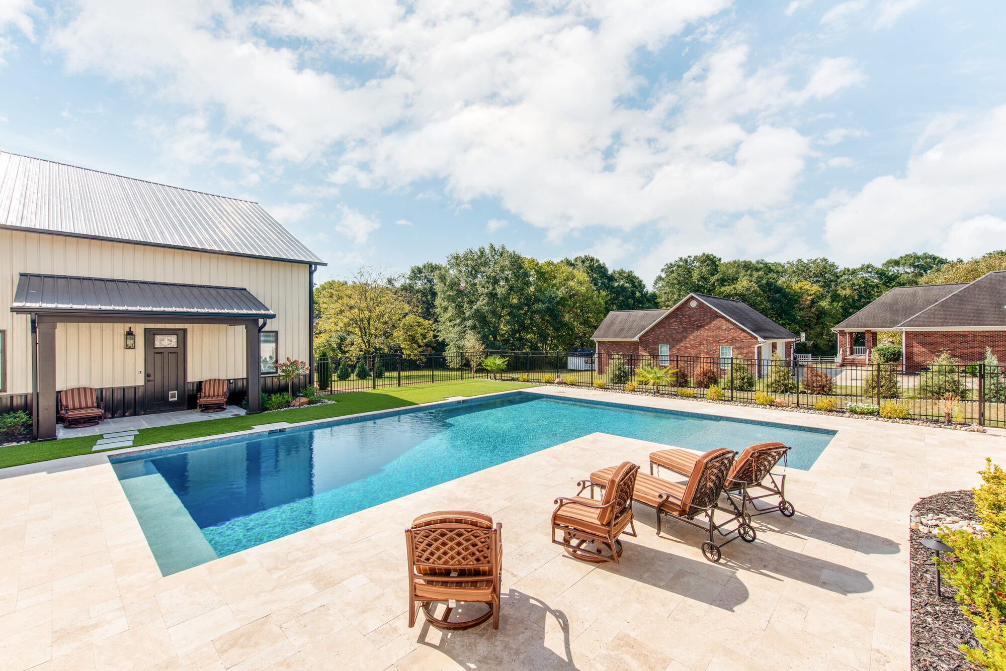Resort-style pool with sunken tanning ledge looking out toward the barndominium — Coddle Creek by Stillman Properties Concord NC