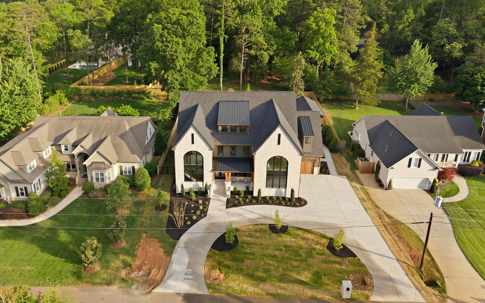 Aerial view of Creola showing the front elevation, circular drive, and wooded lot — Creola custom home in Charlotte NC by Stillman Properties