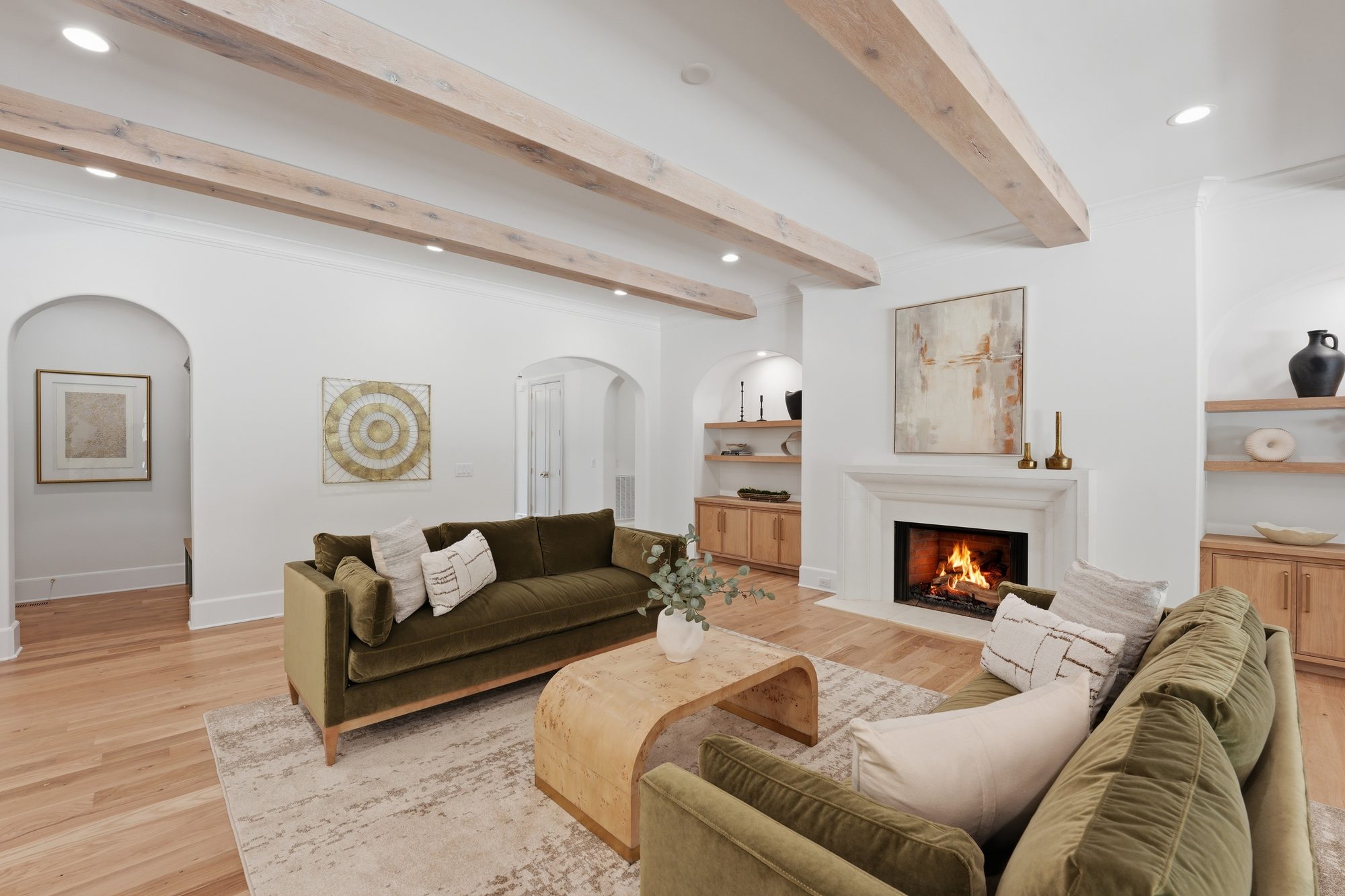 Formal living room with arched display niches and lit limestone fireplace — Creola custom home in Charlotte NC by Stillman Properties