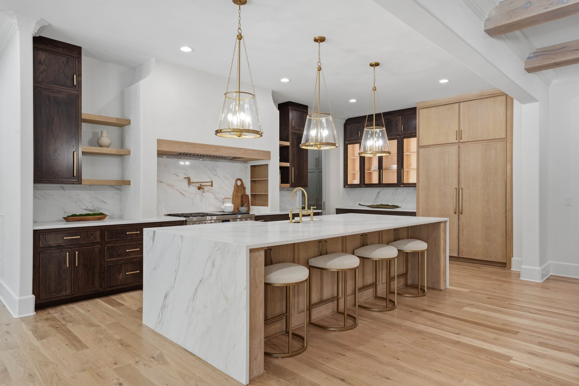 Kitchen range wall with stone surround, brass pot filler, and pro-grade range — Creola custom home in Charlotte NC by Stillman Properties