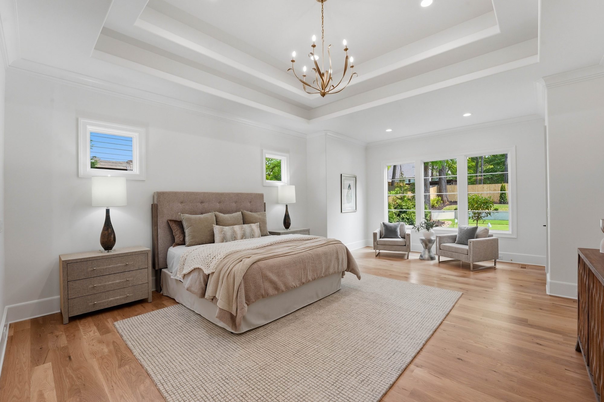 Primary bedroom suite with tray ceiling and brass chandelier — Creola custom home in Charlotte NC by Stillman Properties