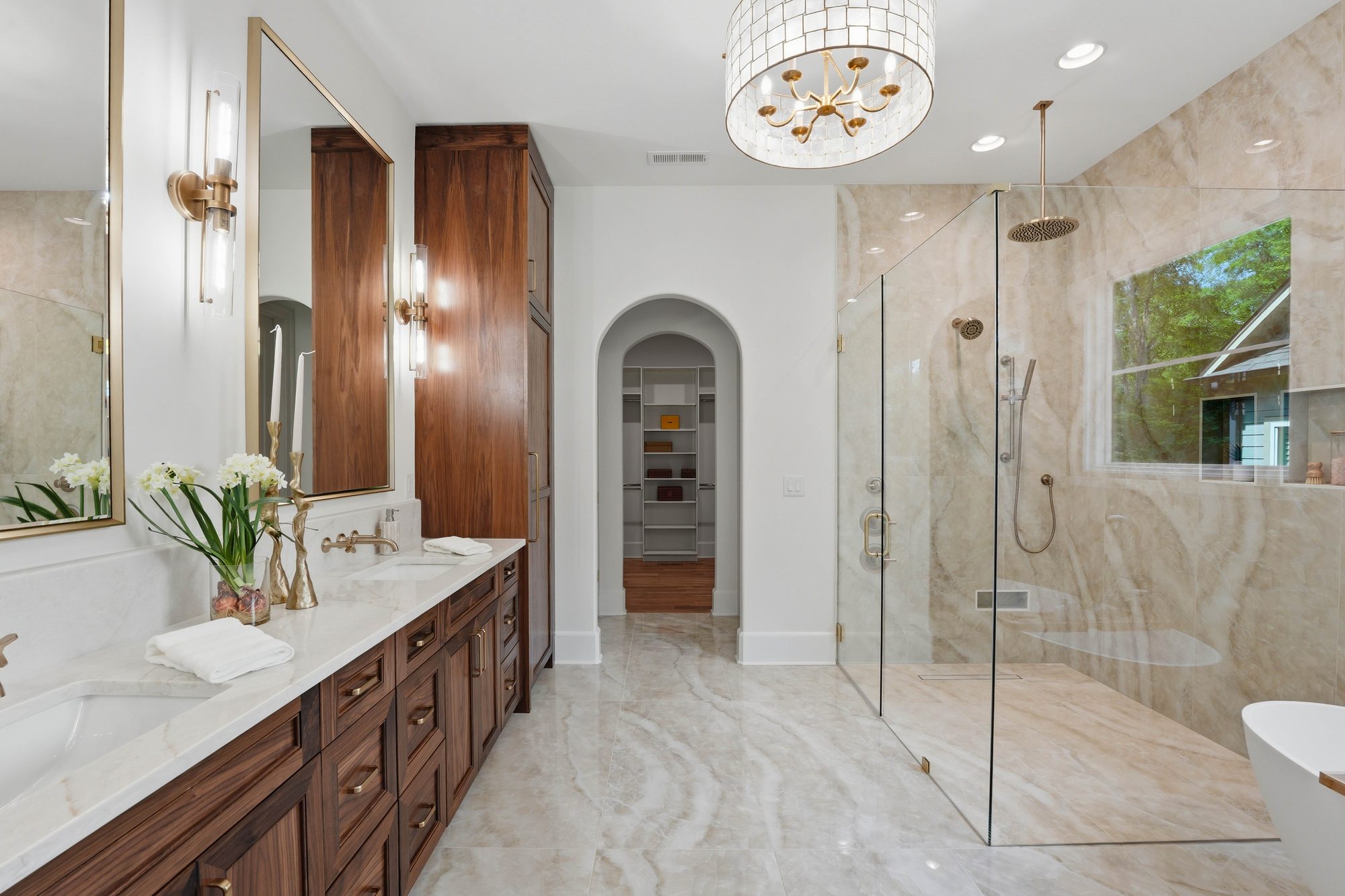 Primary bathroom with walnut vanity, walk-in shower, and brass fixtures — Creola custom home in Charlotte NC by Stillman Properties