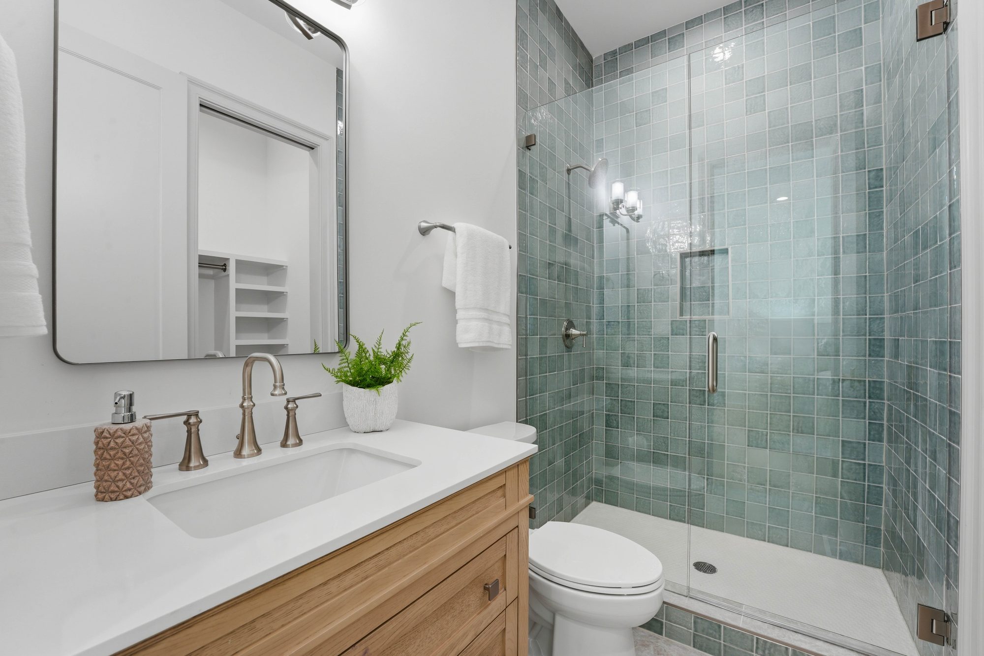 Guest bath with celadon green stacked tile shower and natural oak vanity — Creola custom home in Charlotte NC by Stillman Properties