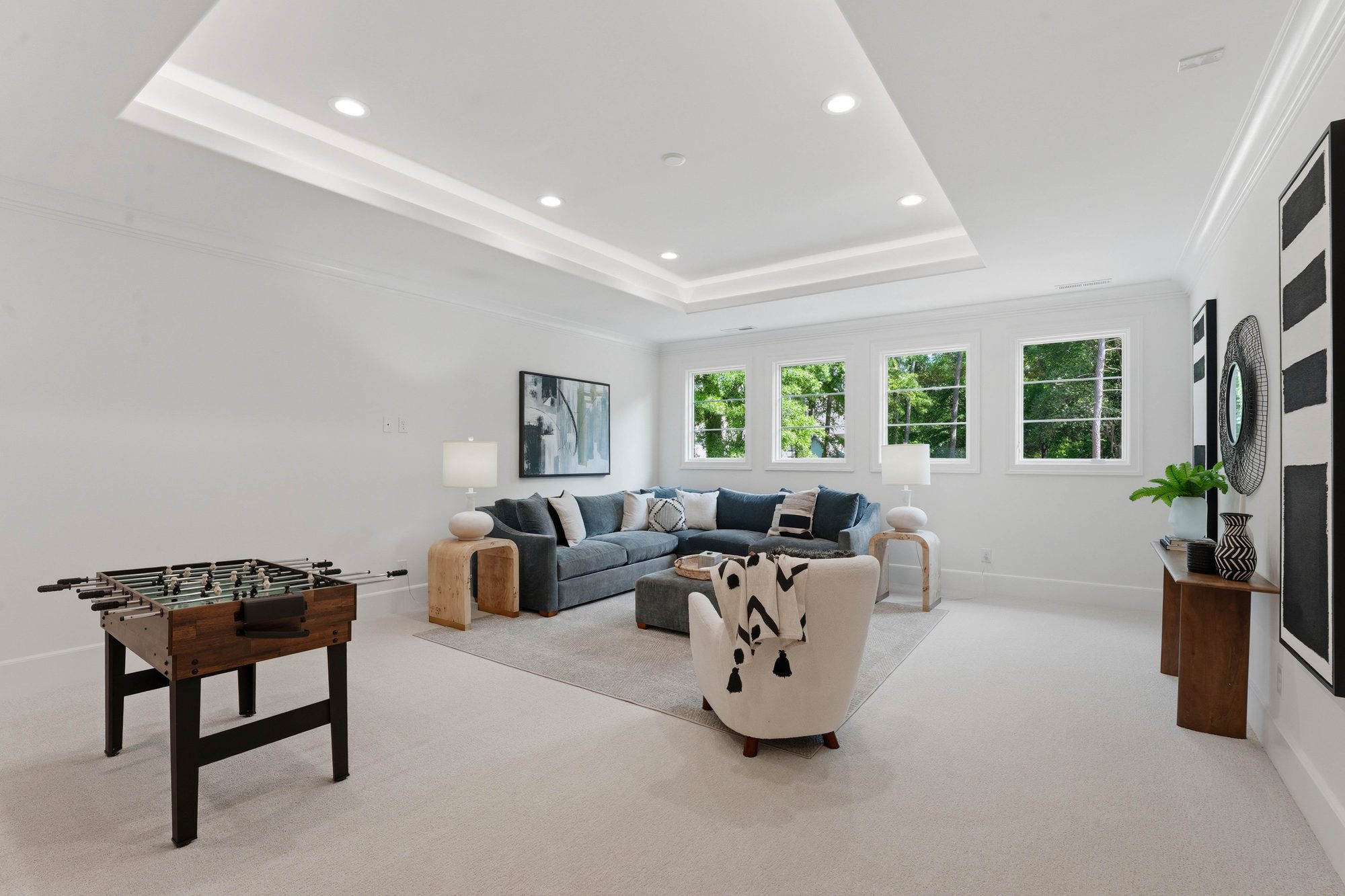Upstairs bonus room with tray ceiling, foosball, and lounge seating — Creola custom home in Charlotte NC by Stillman Properties