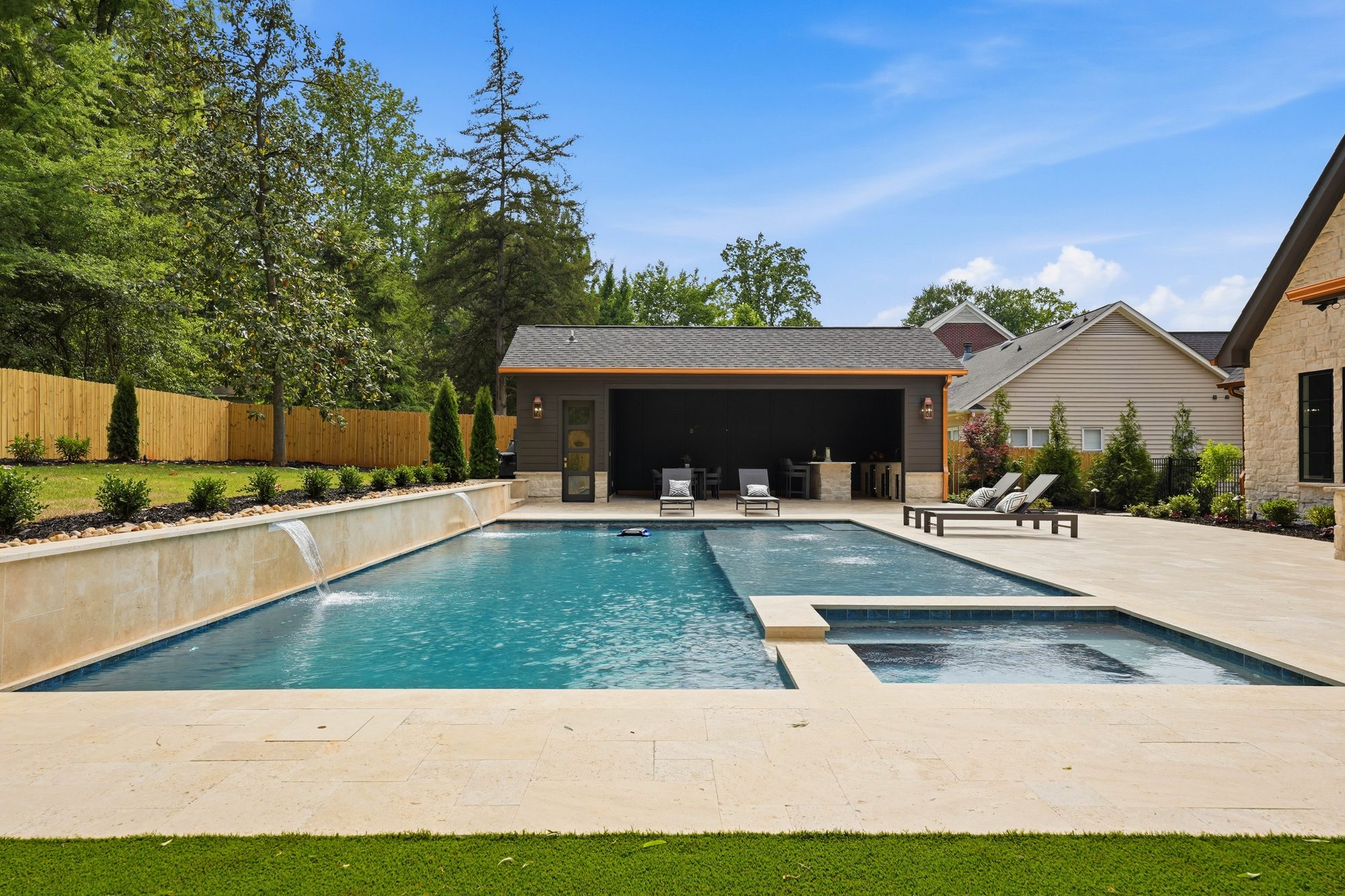 Pool with attached spa and travertine deck during the day — Creola custom home in Charlotte NC by Stillman Properties