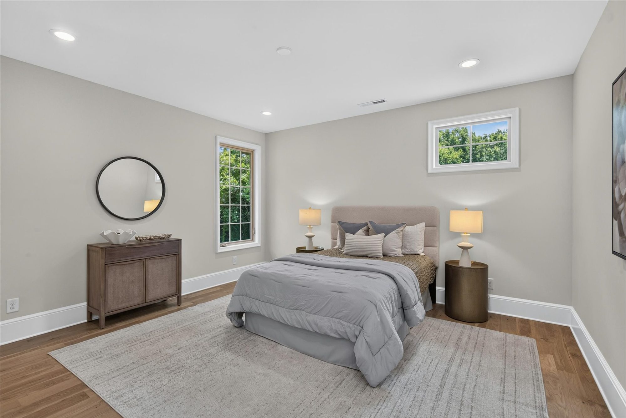 Bedroom at Heather with white oak floors, round mirror, and dual windows — Heather by Stillman Properties Charlotte NC