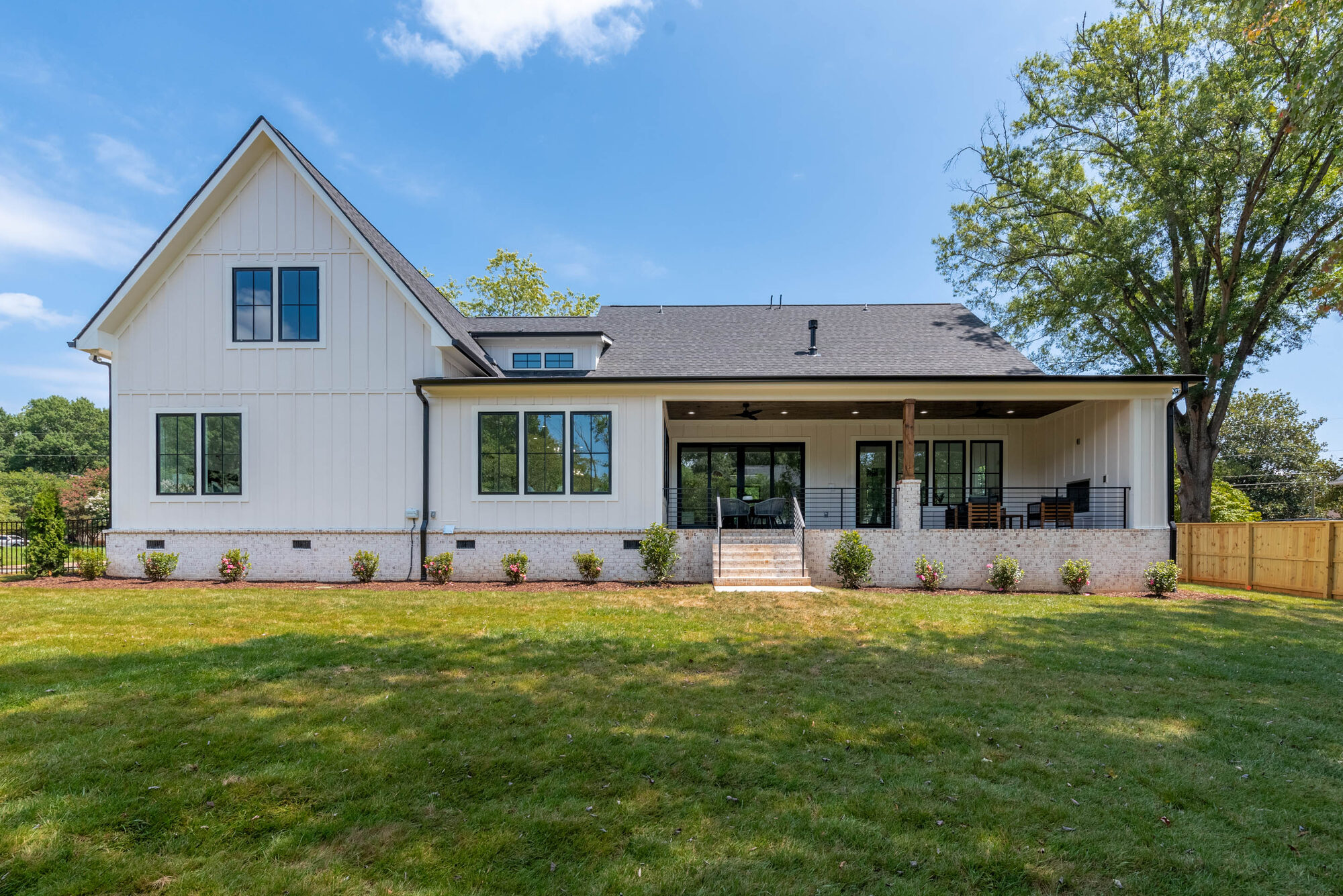 Walker rear elevation with full-length covered deck and board-and-batten siding — Stillman Properties Cotswold Charlotte NC