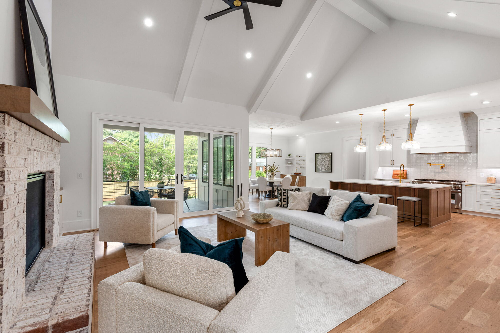 Walker vaulted great room open to kitchen, with painted exposed beams and whitewashed brick fireplace — Stillman Properties Cotswold Charlotte NC