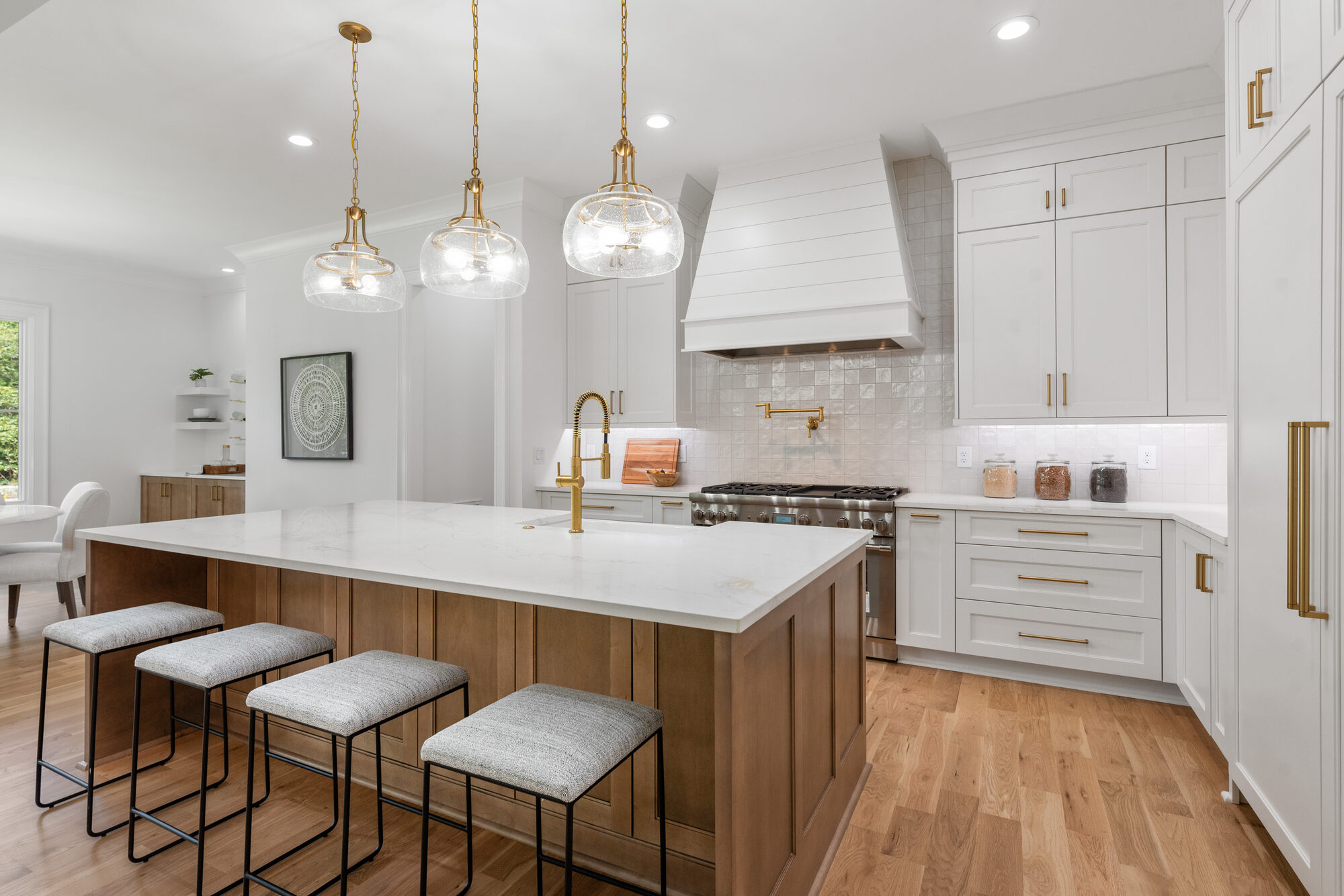 Walker kitchen alternate view showing Wolf range, brass pot filler, and square tile backsplash — Stillman Properties Cotswold Charlotte NC