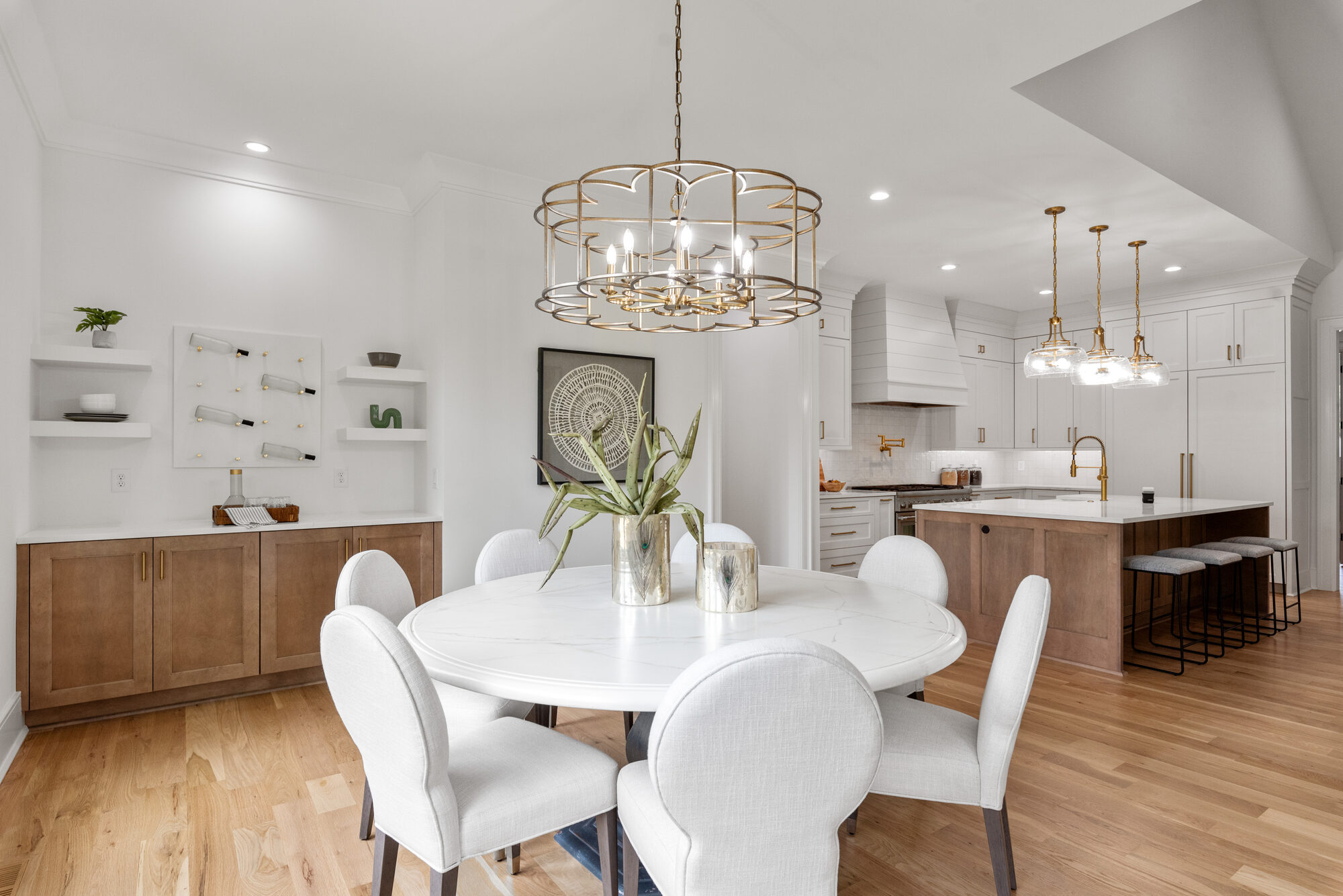 Walker dining area with built-in wet bar, brass chandelier, and sightline to the kitchen — Stillman Properties Cotswold Charlotte NC