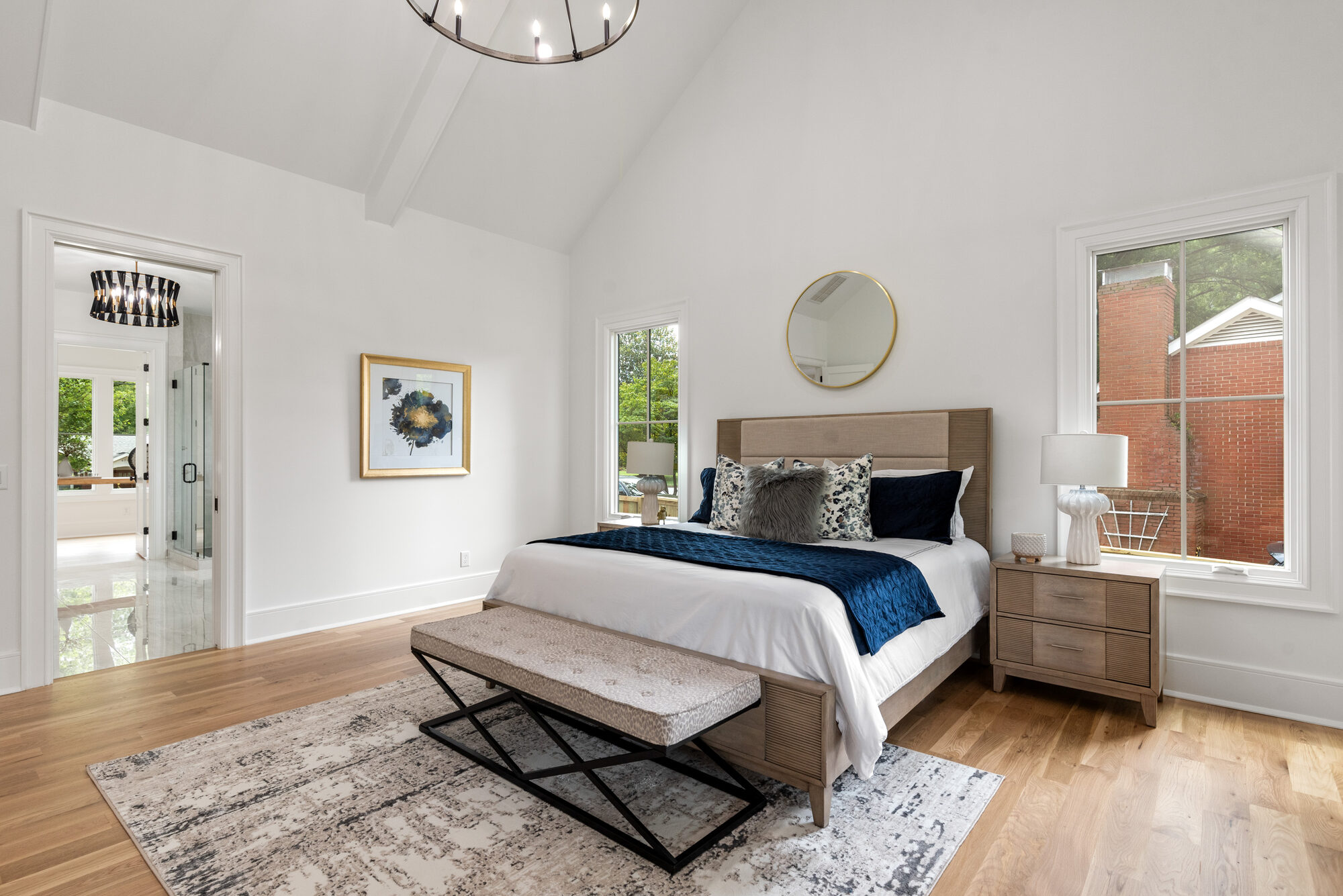 Walker primary bedroom alternate angle showing brass mirror, vaulted ceiling, and bath access — Stillman Properties Cotswold Charlotte NC