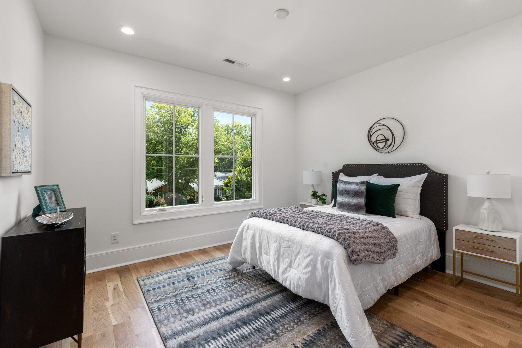 Walker guest bedroom with nailhead upholstered headboard and casement window — Stillman Properties Cotswold Charlotte NC