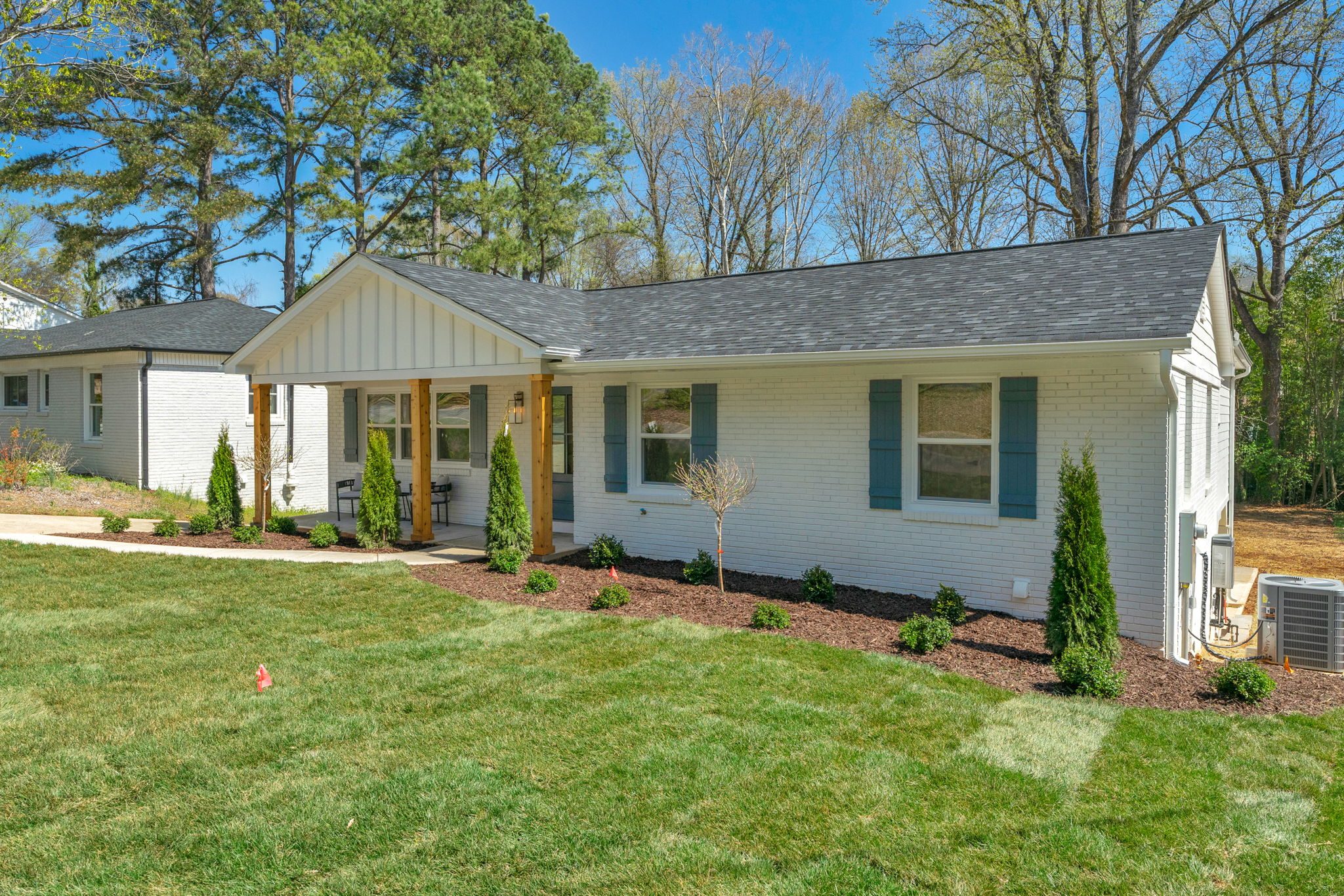 Renovated ranch-style front exterior with new board-and-batten siding and cedar-post porch — Wyanoke by Stillman Properties Charlotte NC