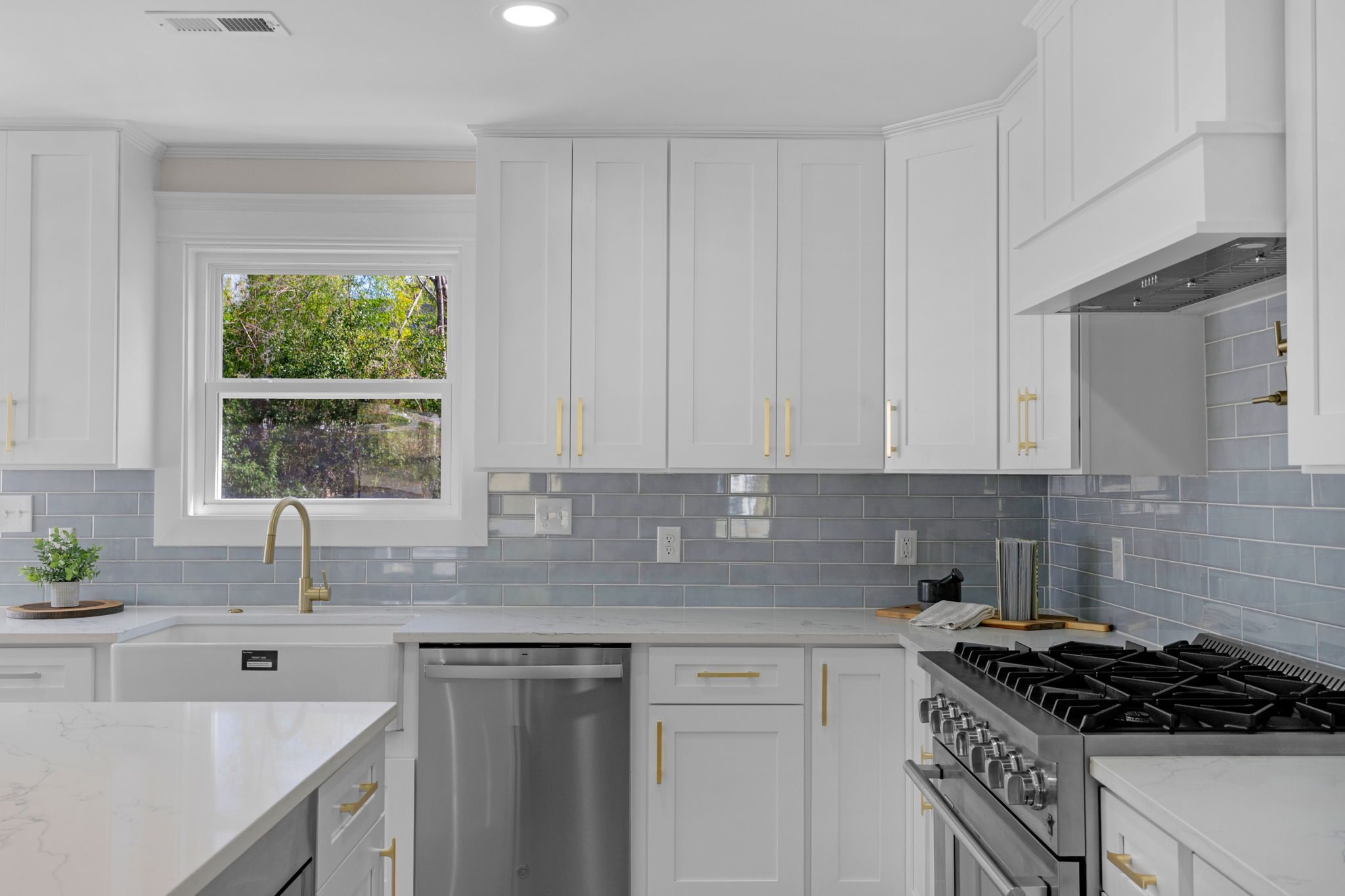 Kitchen sink wall with tile backsplash, gold fixtures, and stainless appliances — Wyanoke by Stillman Properties Charlotte NC