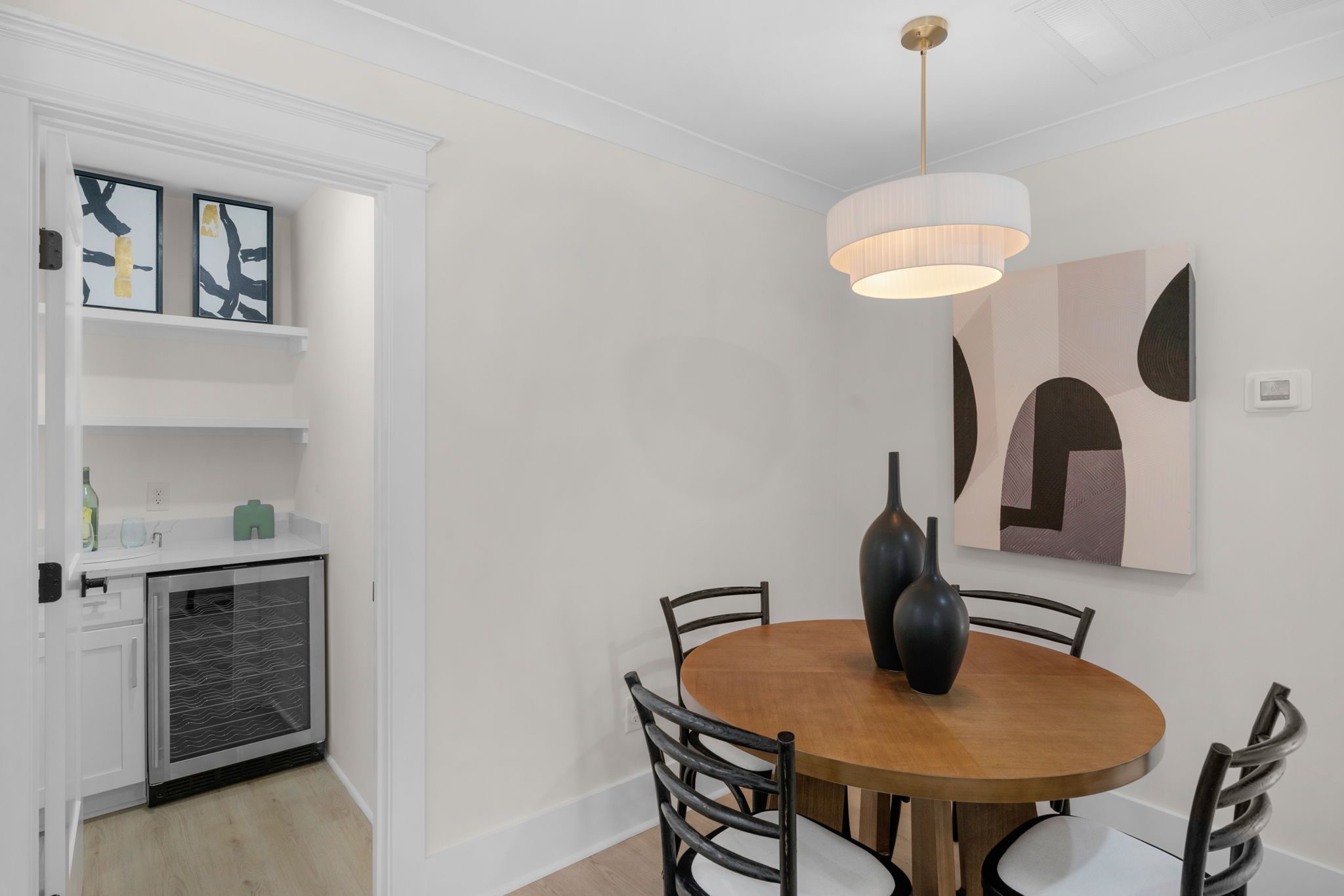 Dining area with round table, modern pendant, and built-in beverage center — Wyanoke by Stillman Properties Charlotte NC